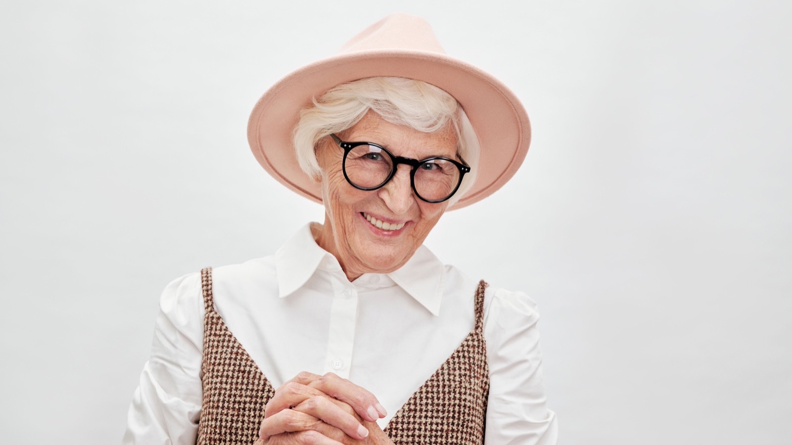 Senior souriante avec un chapeau rose, comparer le viager et les autres solutions